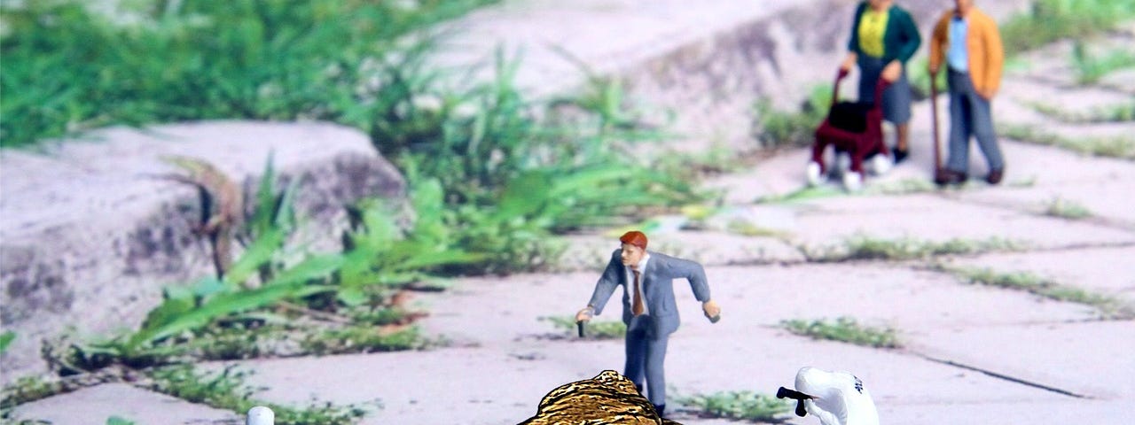 Forensics, miniature model people surround and inspect a pile of golden poop