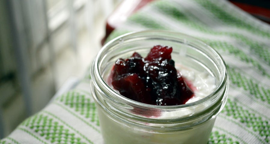 Homemade yogurt in a mason jar topped with jam