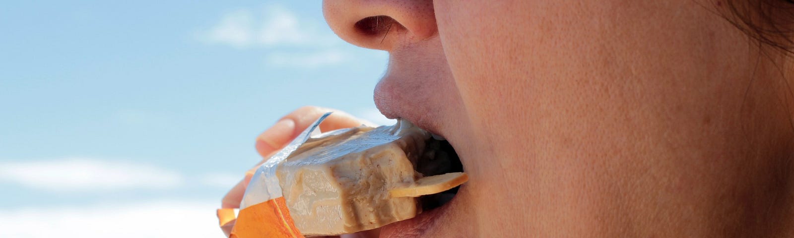 Woman at the beach eating ice-cream.