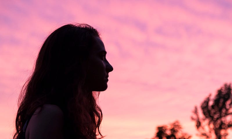 girl’s silhouette against pink sky