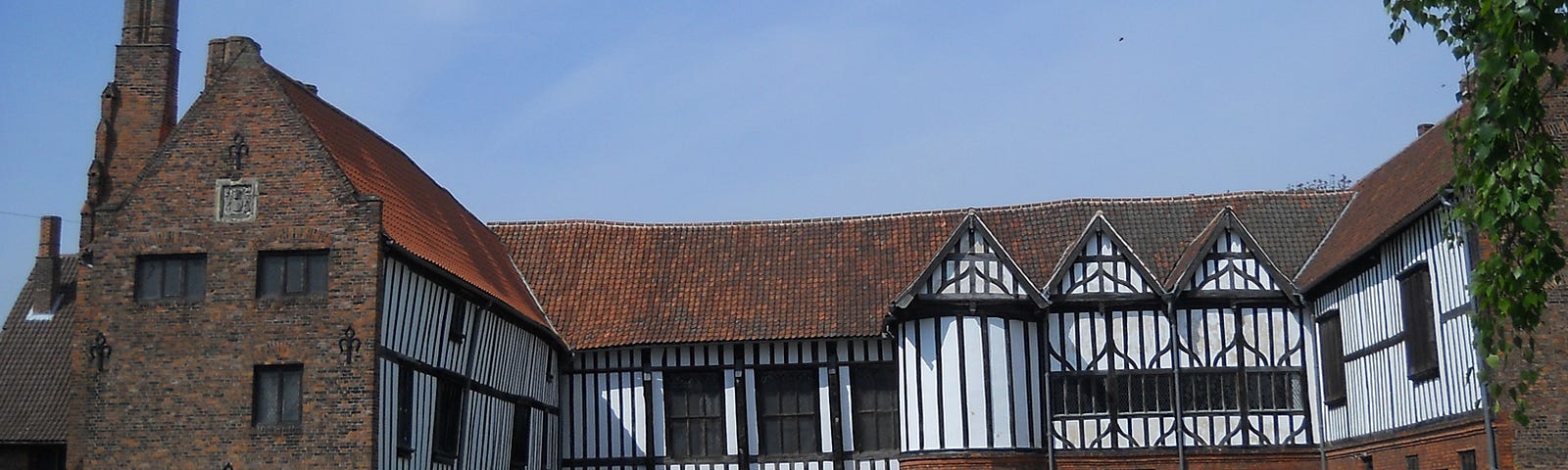 Horse-shoe shaped Gainsborough Old Hall, built 1460, in red brick and black lath & white-washed plaster.