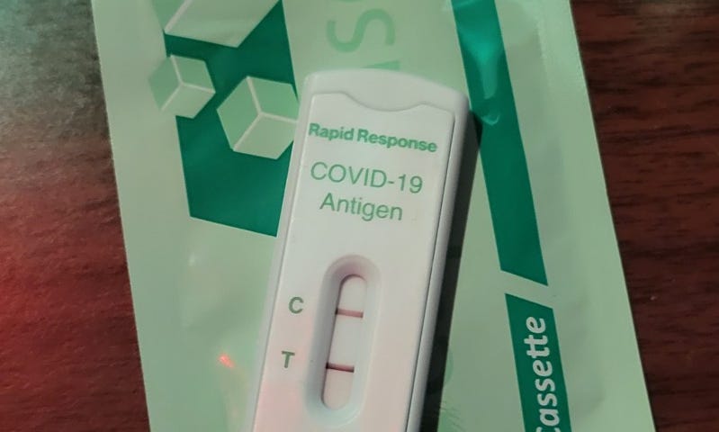 A photo of a covid rapid test showing 2 lines, a positive result.