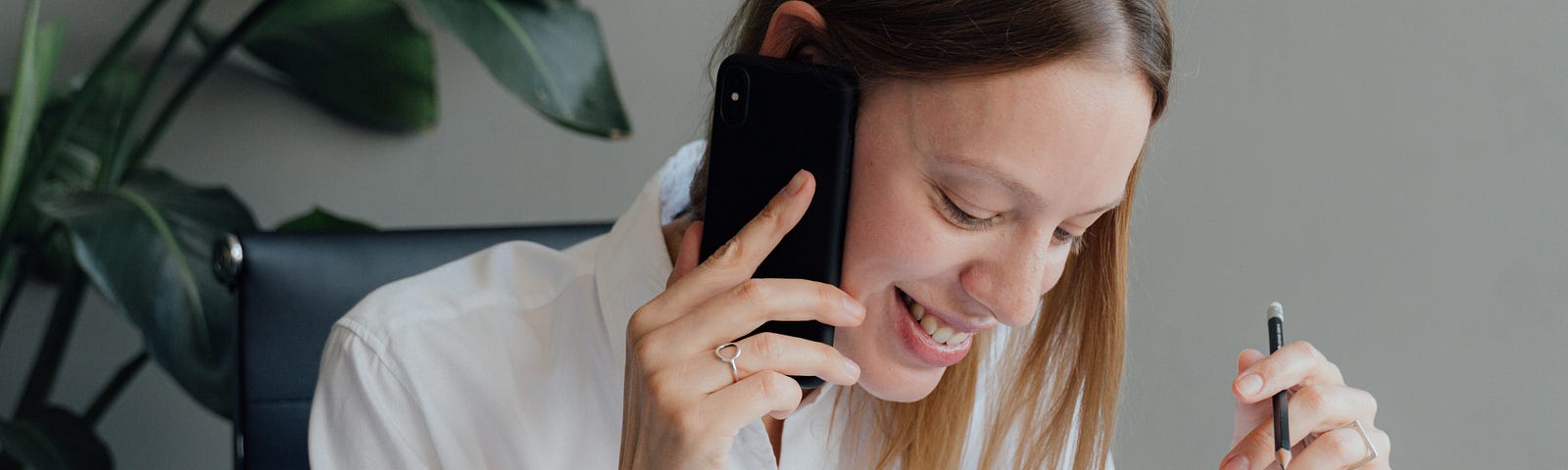 Woman calling client on her iphone about design drafts