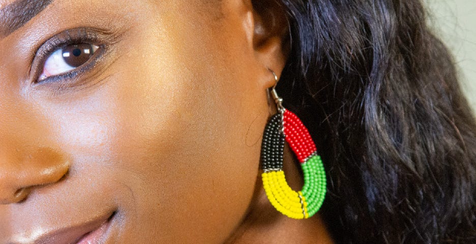 Model wearing a four-color bead earring with one eye visible