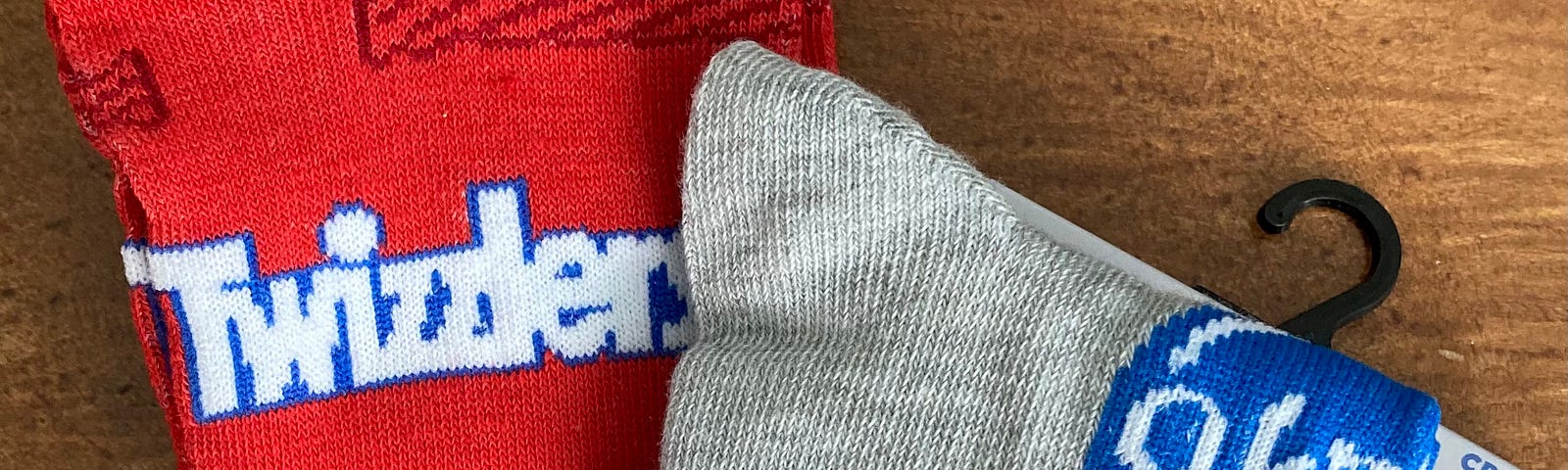 a photo of two pairs of crew socks, a red pair with the Twizzlers logo and a gray pair with the York logo