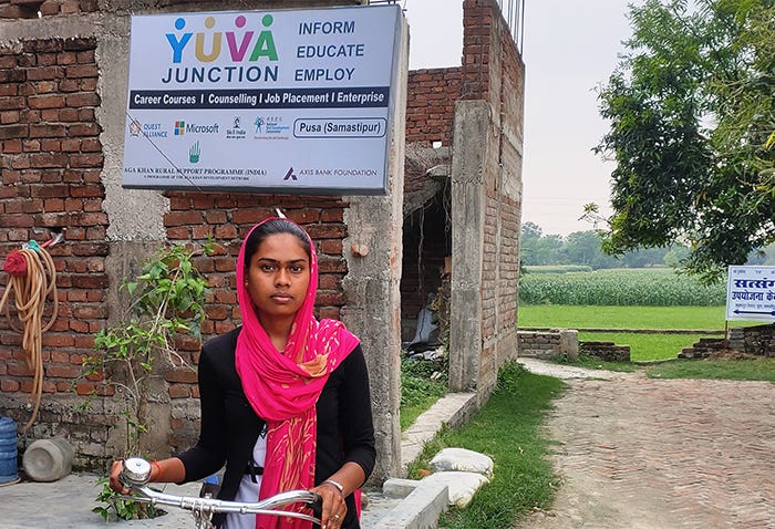 A young woman stands outside a youth skills development center.