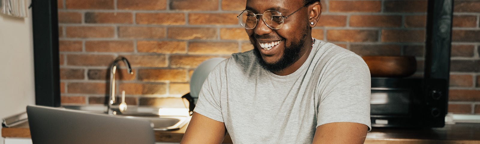 A Smiling Man Using a Laptop