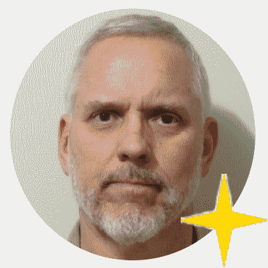 Author’s own face, a caucasian male, with brown eyes, and neatly trimmed grey short hair and beard, with his own gold four point star he constructed sitting at the lower right corner of his encircled face in this portrait.