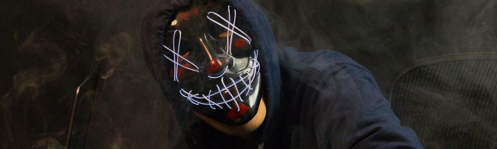 A masked hacker at a keyboard.