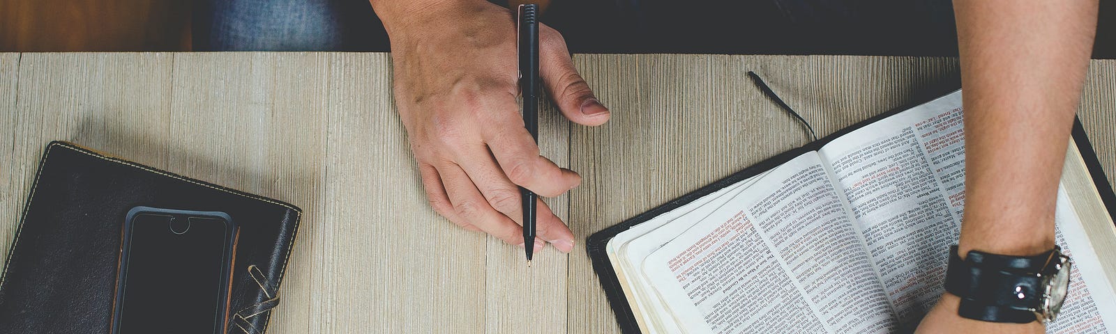 person holding Bible with pen