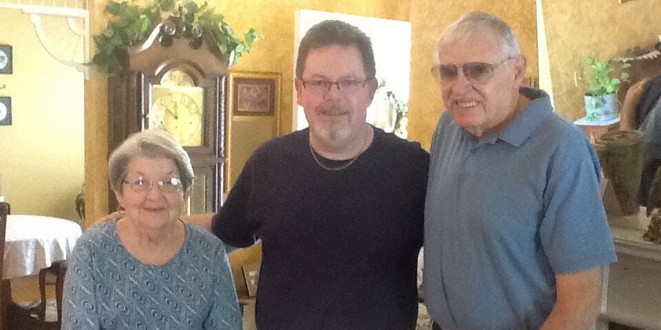 Family photo of an older couple and a younger man.