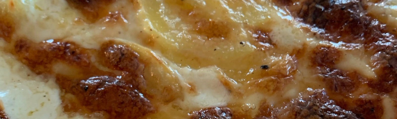 Gratin Dauphinois bubbling, brown, just out of the oven,