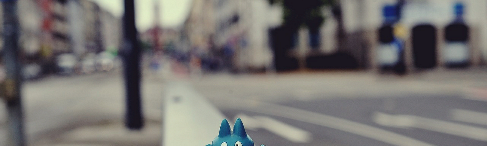 Pokemon action figure kicking Twitter pill on the road.