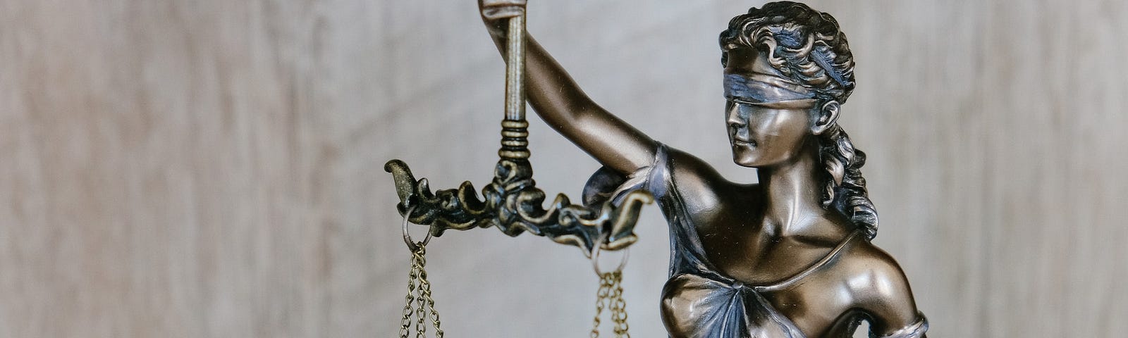 A bronze statue of Lady Justice holding a set of scales