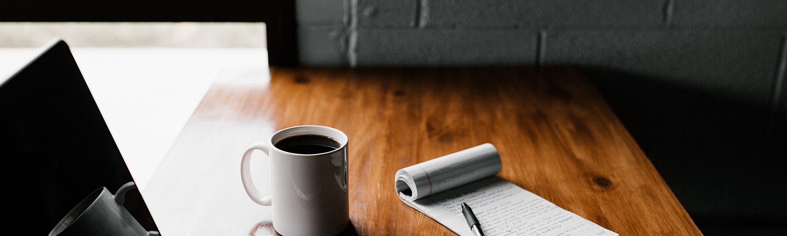 Photo by Andrew Neel on Unsplash — Computer, mug, phone and notepad at desk