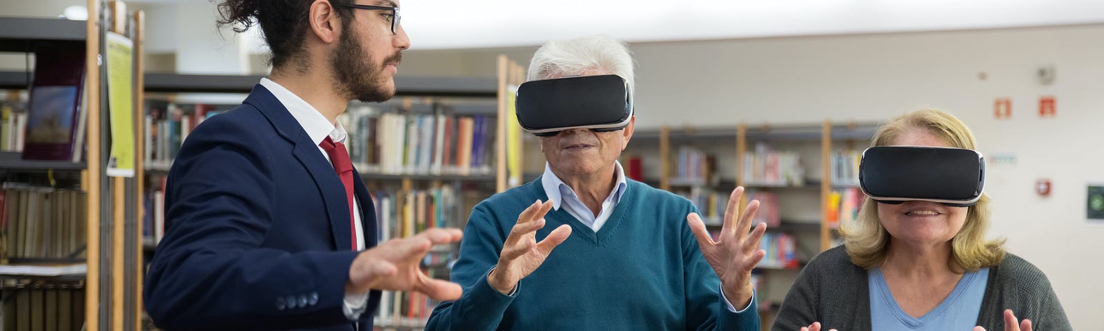 An elderly couple in VR glasses, assisted by a younger man in normal glasses