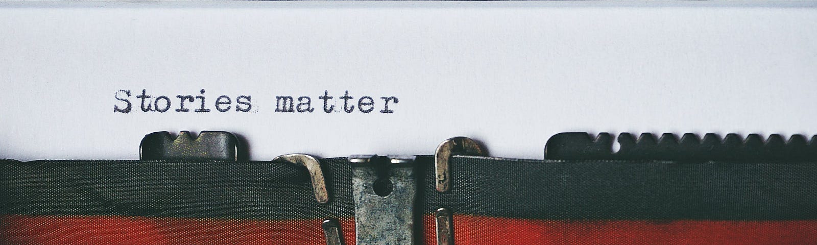 black & red typewriter with “stories matter” written on paper