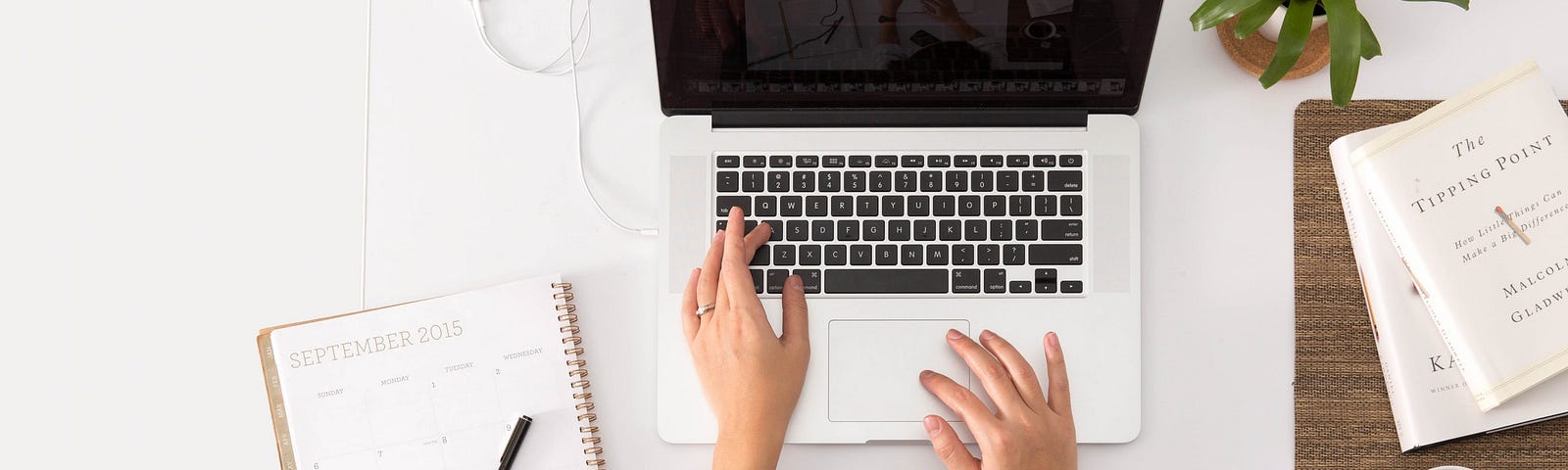 Overhead view of hands typing on a laptop.