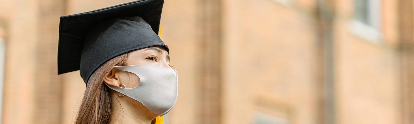 A college graduate wearing a face mask.