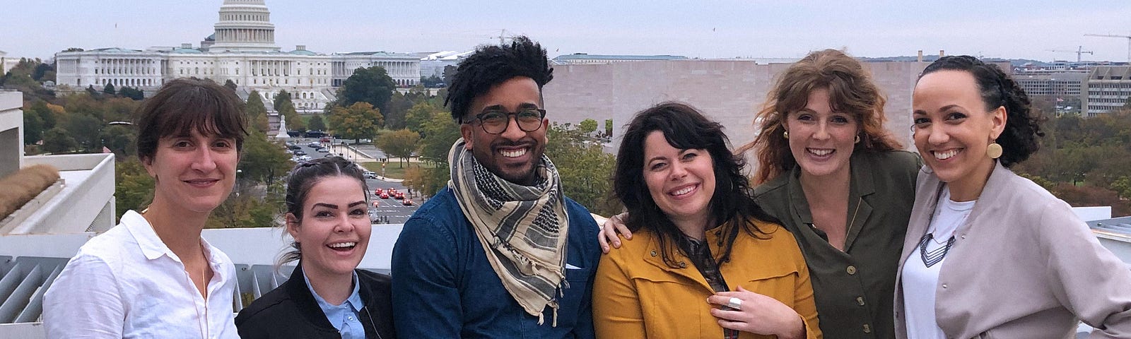 Members of the &Partners team standing on the roof overlooking the capitol building at the AGL summit.