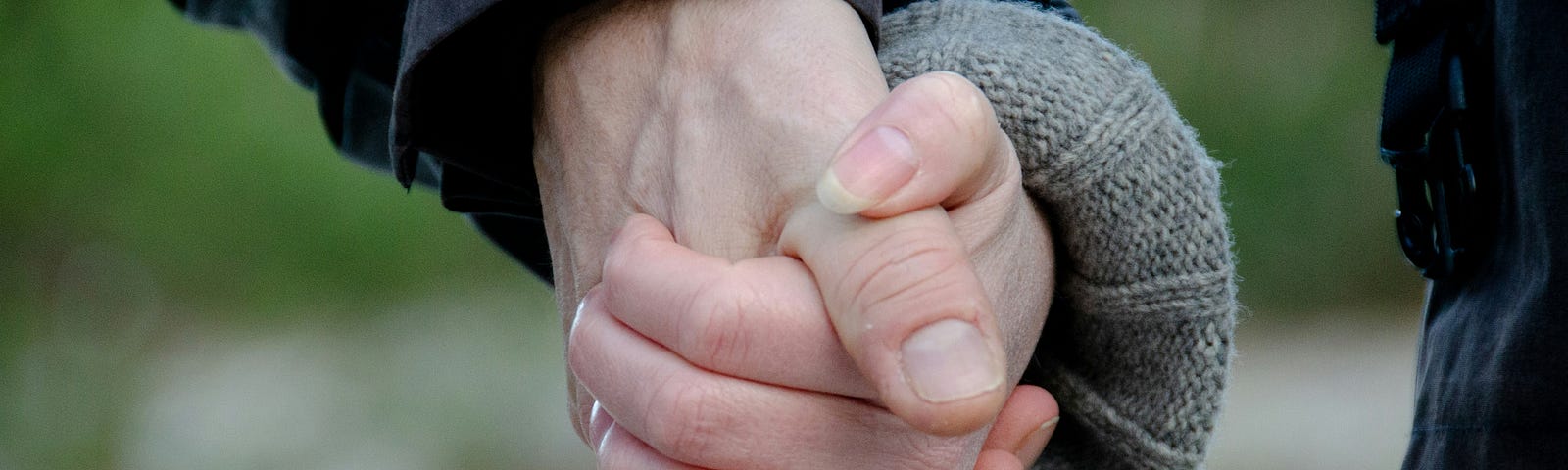 Photo of hands holding showing a ring on one finger