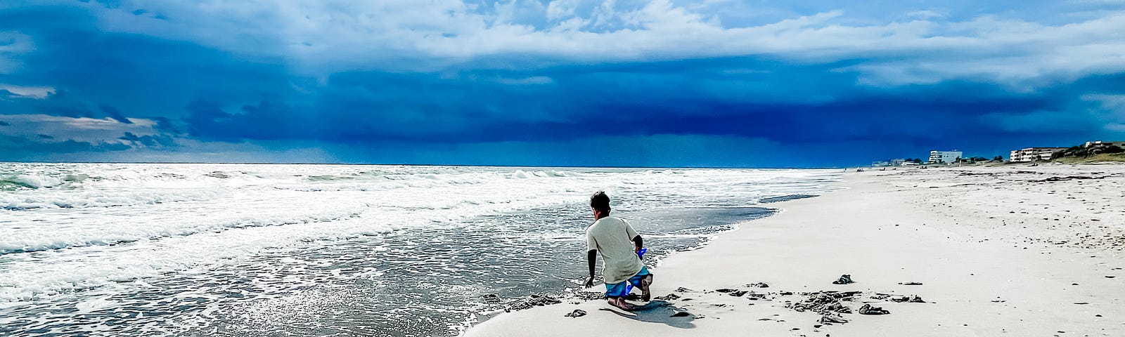 Picture of a lone boy on an isolated stretch of the beach in the early morning.