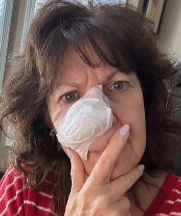 Woman’s face with large bandage over her nose.
