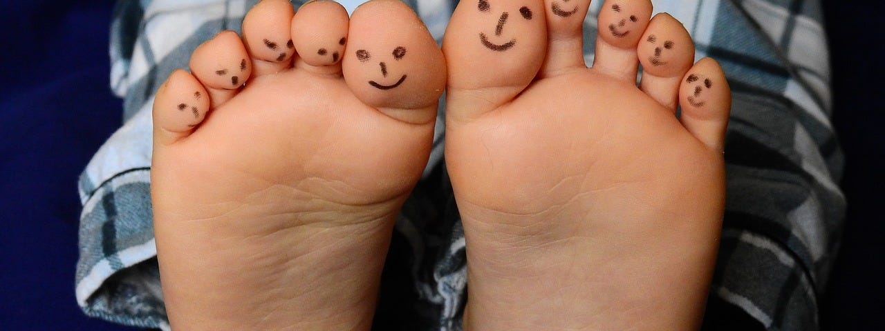 bare feet with faces painted on the ten toes. Reflexology