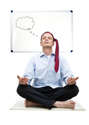 An executive meditating in front of a blank whiteboard