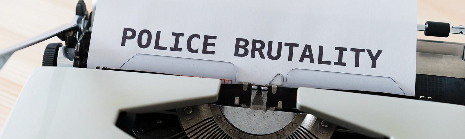 Typewriter with the phrase Police Brutality in big font at top of page