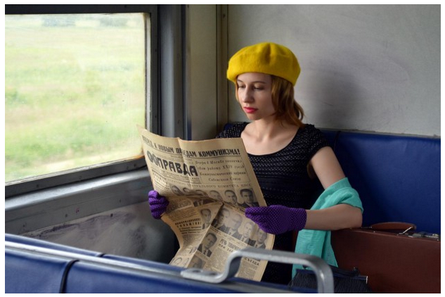 Woman reading a newspaper on a train