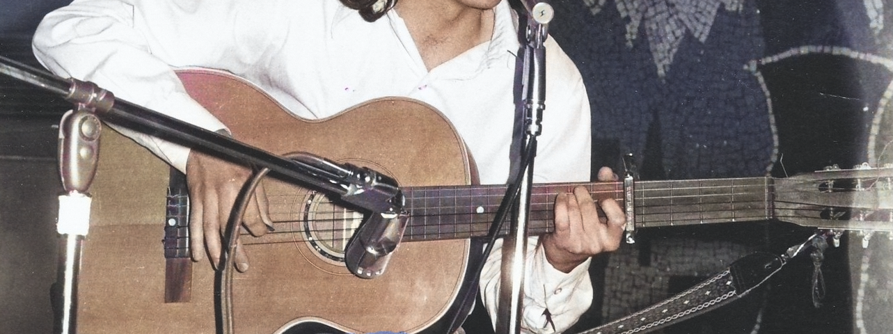 Young man playing guitar on stage