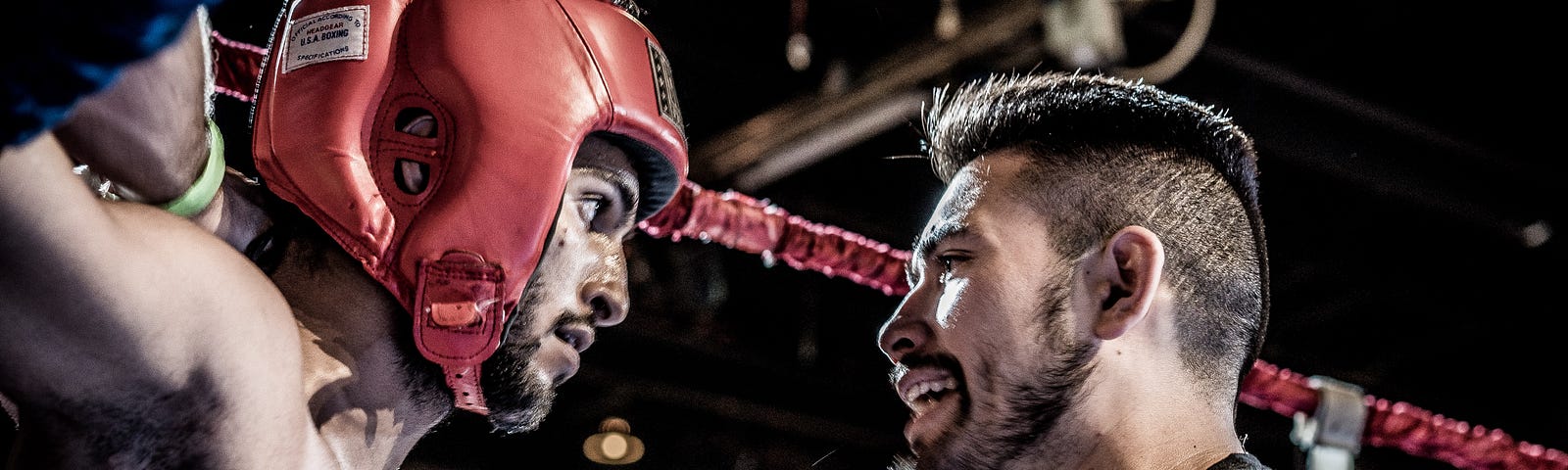 A coaching and a boxer in a boxing ring.