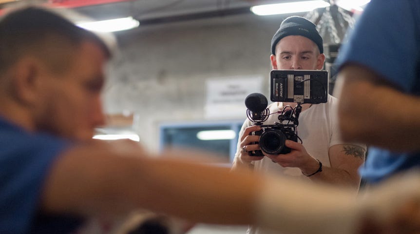 Man filming boxer in gym