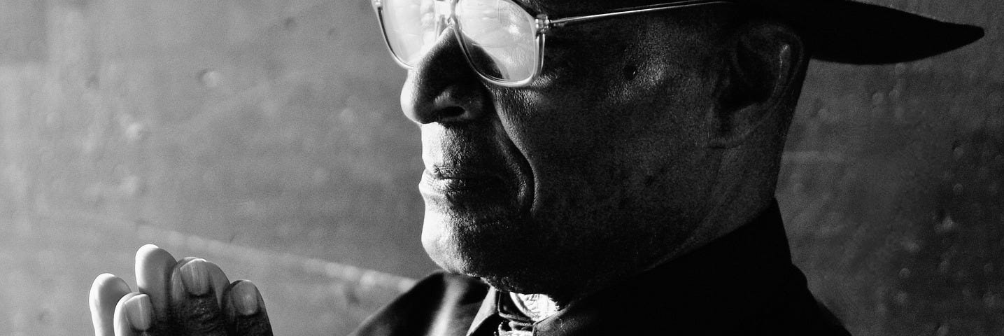 Black & White photo of Black man with praying hands