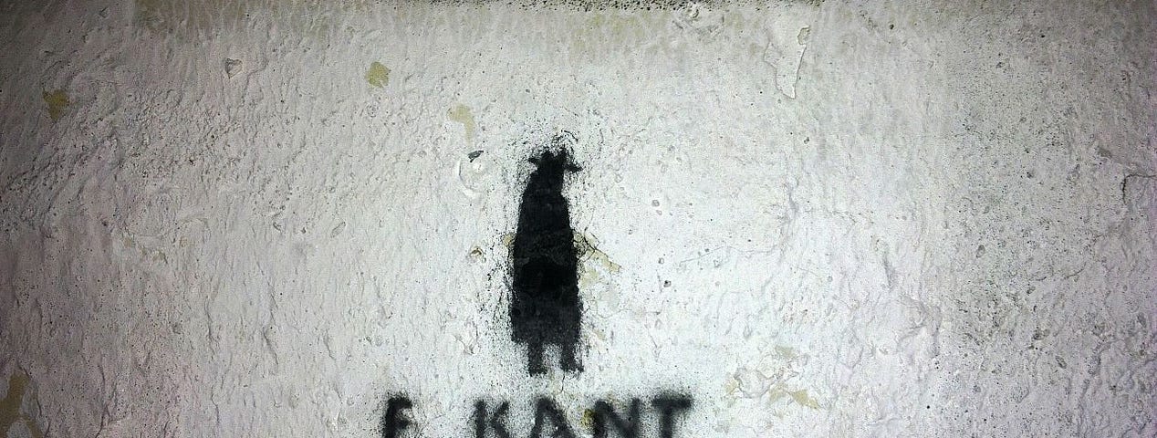 A painting of a dark figure on a wall with “E. Kant” printed below it.