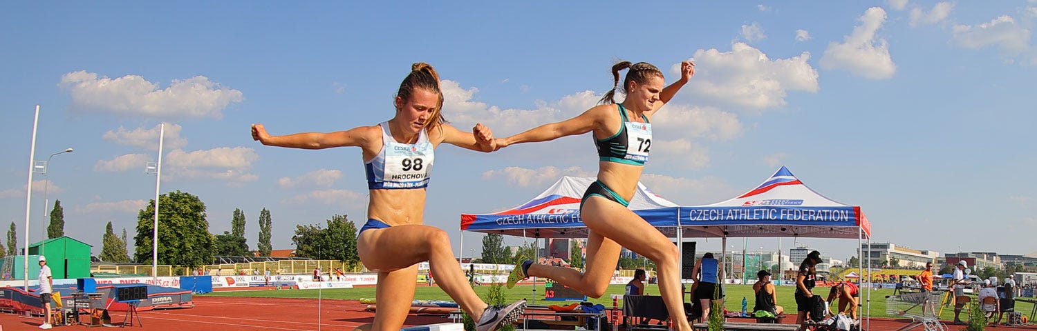 An action shot: Tereza (author) and another runner jump over a water pit during the 3000 meter steeplechase.