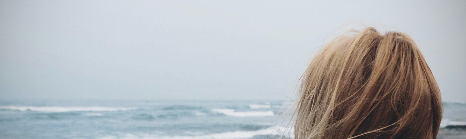 A woman looks out over the ocean