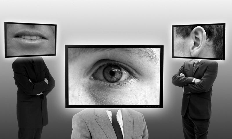 IMAGE: In black and white, three persons with sinister appearance dressed in corporate attire with monitors as heads, one with a big eye, another one with a big ear and a third one with big mouth on them