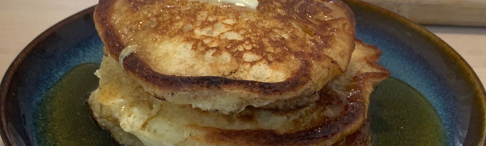 This is a photo of a stack of pancakes on a blue plate