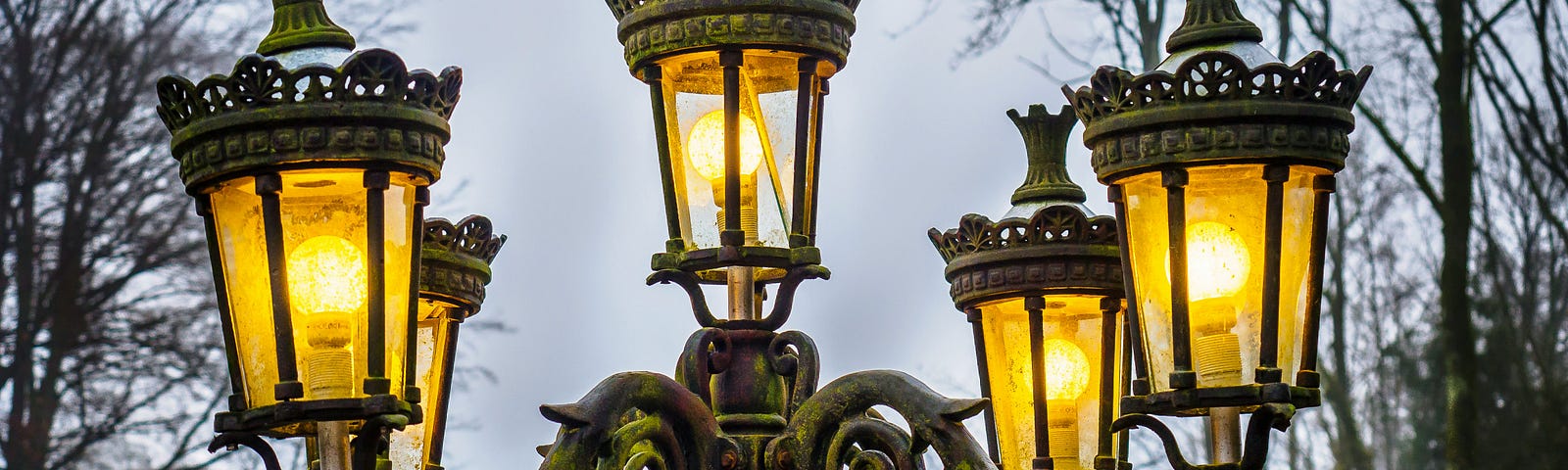 A Victorian lampost with 5-lit bulbs in individual glass canisters.
