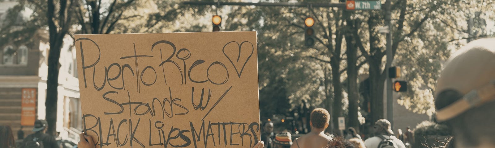 Protester with a sign saying “Puerto Rico stands with Black Lives Matter”