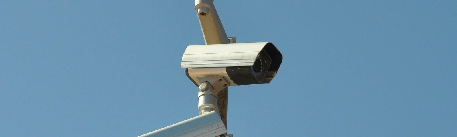 Four surveillance cameras pointed at slightly different angles all on one post