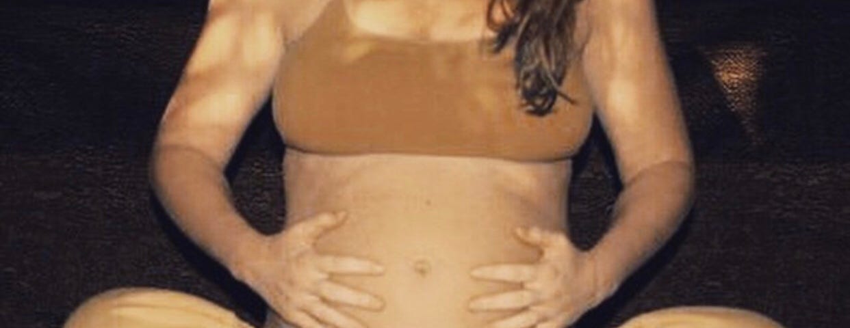 A pregnant woman doing prenatal yoga, concerned about weight gain in pregnancy.