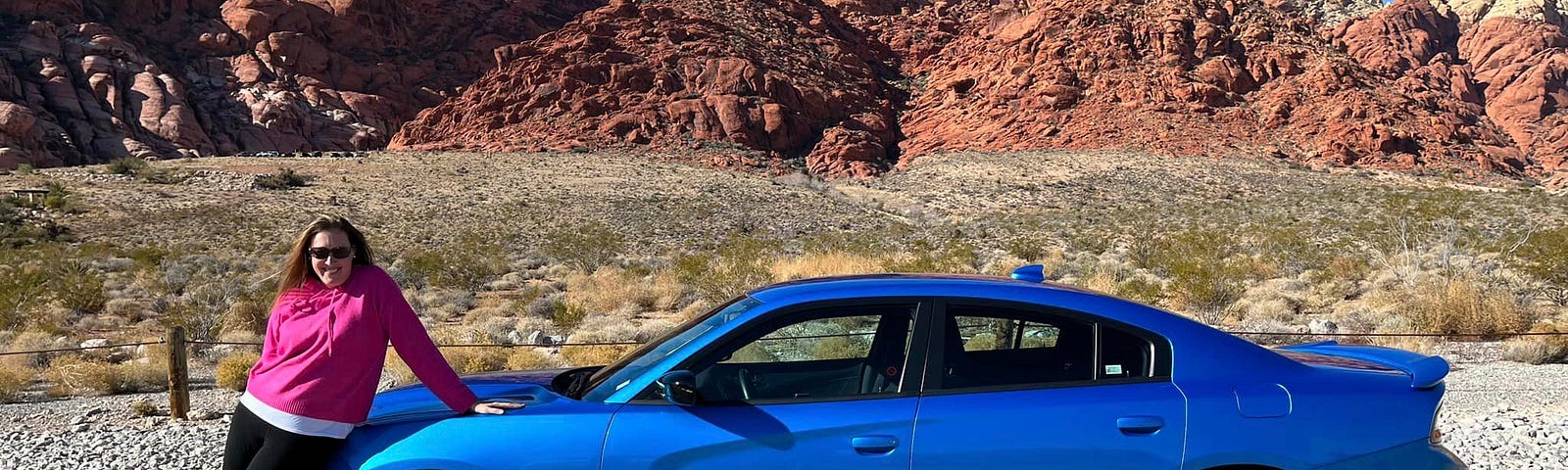 The author leaning against a royal blue Mustang. Red Rocks of Vegas behind