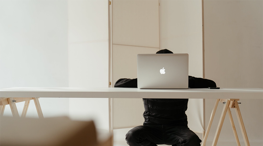 guy exploring his options on his laptop from his desk