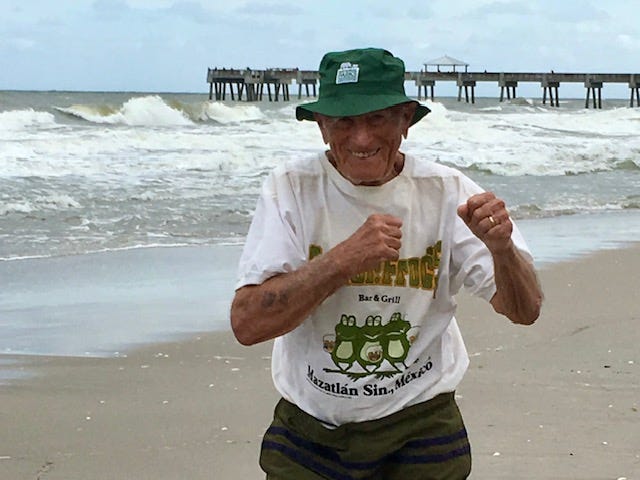 My father boxing the air with a big smile on the beach a few years ago.