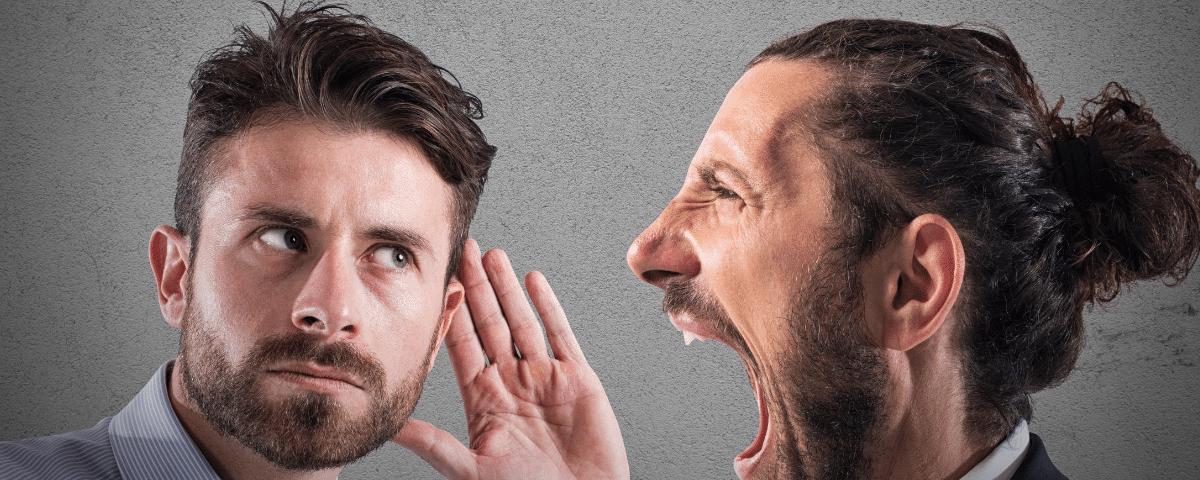 man shouting at auditory impaired man without being heard