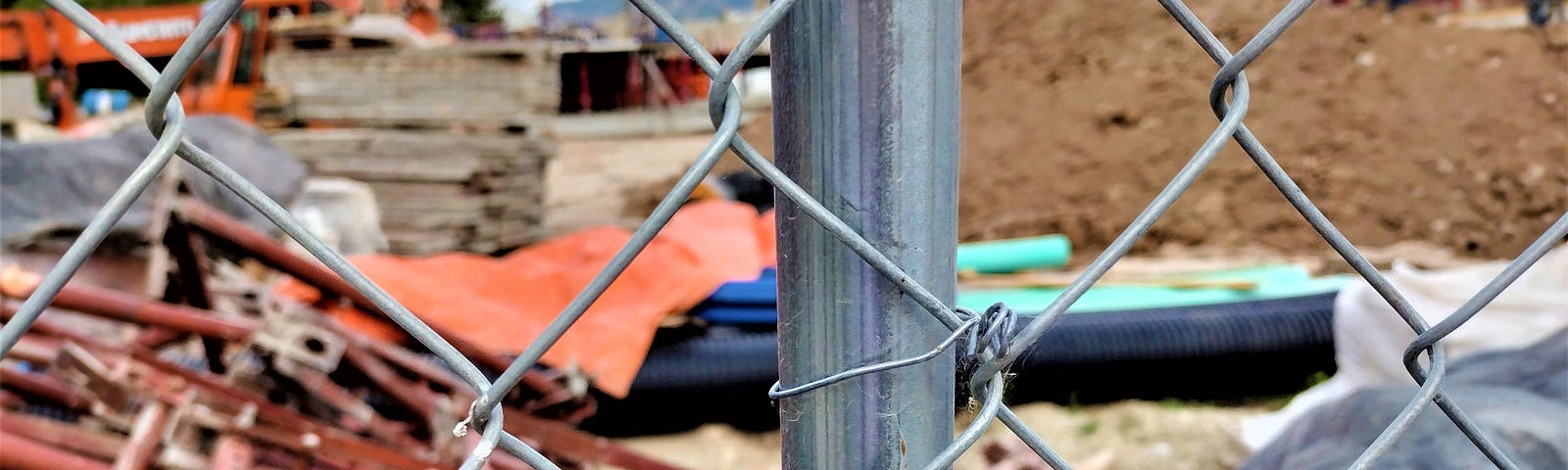 A construction site seen through a chain link fence