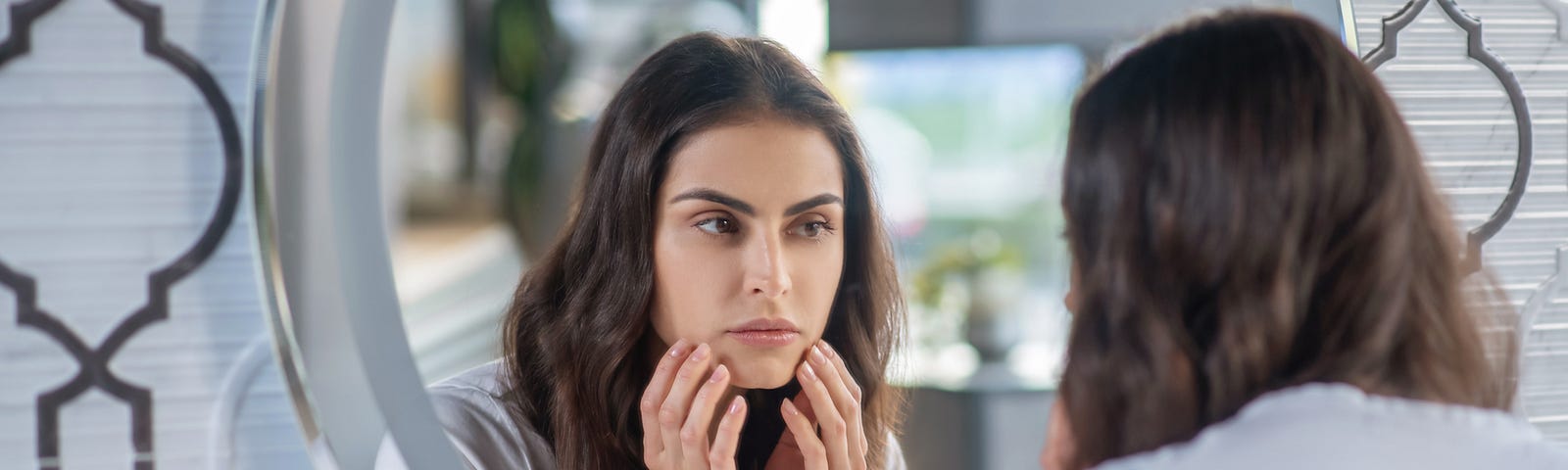 A woman looking at herself in the mirror.